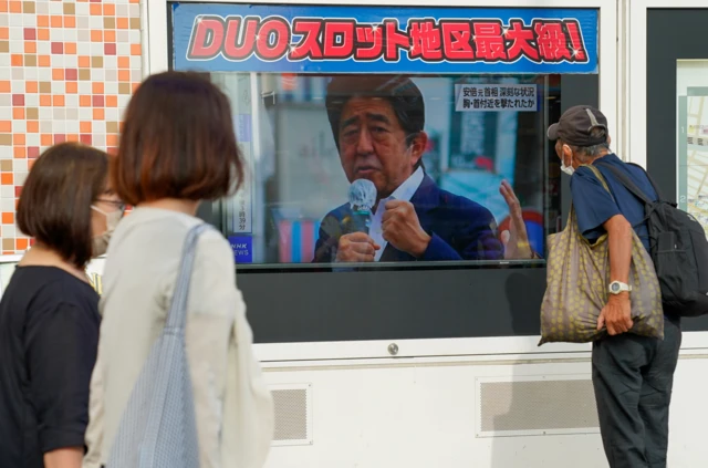 People watch a broadcasting screen in Japan