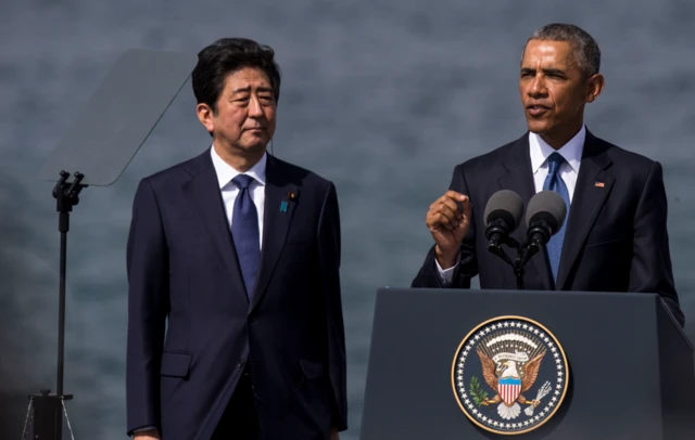 U.S. President Barack Obama delivers remarks while Japanese Prime Minister Shinzo Abe listens at Joint Base Pearl Harbor Hickam's Kilo Pier on December 27, 2016