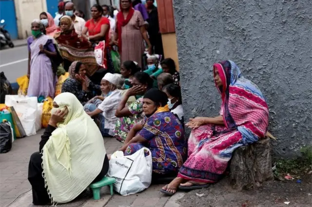 People wait in a line on a pavement near a distributor to buy kerosene oil for their cookers due to domestic gas shortage, amid the country"s economic crisis, in Colombo, Sri Lanka, May 24, 2022.