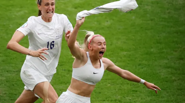 Chloe Kelly waves her England shirt above her head after scoring the winning goal