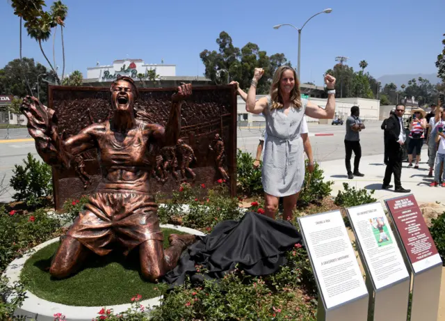 Brandi Chastain with her statue outside the Rose Bowl