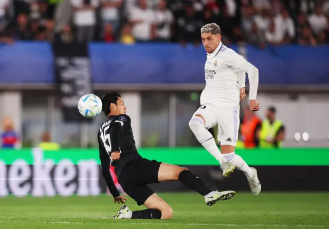 Daichi Kamada of Eintracht Frankfurt is challenged by Federico Valverde of Real Madrid