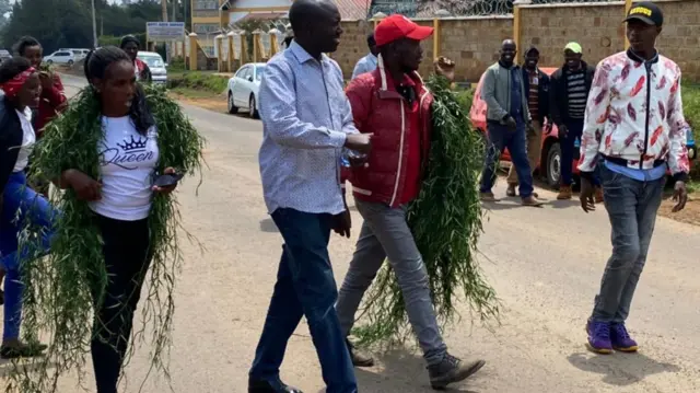 People wearing grass laurels in Eldoret, Kenya