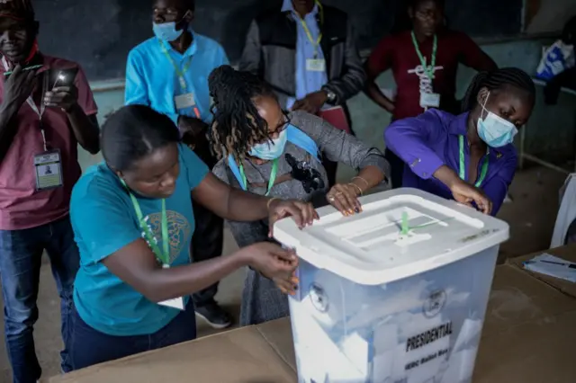 Independent Electoral and Boundaries Commission (IEBC) officials break the seal of ballot boxes before counting during Kenya's general elections at a polling station in Kisumu on August 9, 2022