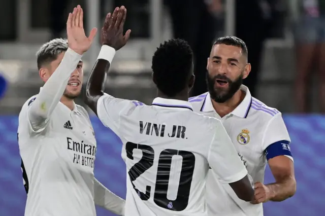 Real Madrid's French forward Karim Benzema celebrates scoring the 2-0 goal with his team-mates Real Madrid's Brazilian forward Vinicius Junior and Real Madrid's Uruguayan midfielder Federico Valverde