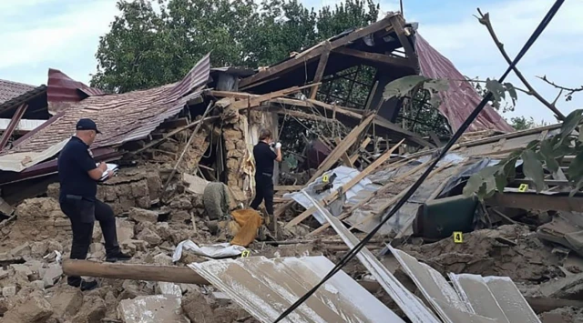 A handout picture made available by the Ukrainian National Police's press service shows the experts inspect a damaged private building after shelling in Marhanets of Dnipropetrovsk area, Ukraine, 10 August 2022.