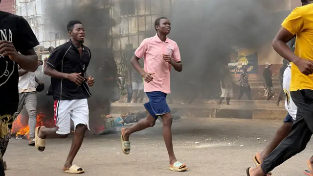 People run away during an anti-government protest, in Freetown, Sierra Leone, August 10, 2022