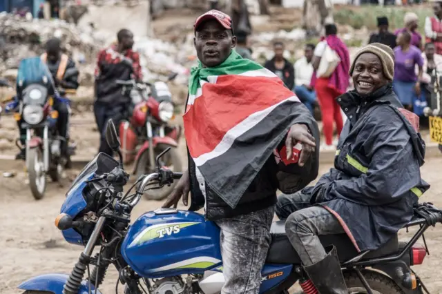 A boda-boda driver and a rider smile