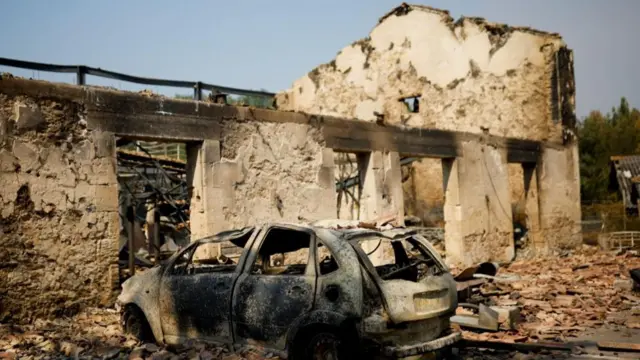 A view of a house and a car destroyed by fire in Belin-Beliet, as wildfires continue to spread in the Gironde region of southwestern France, August 11, 2022