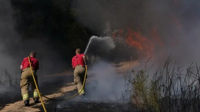 A firefighter extinguishes a blaze with a hose