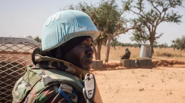 A Senegalese Blue Helmet peacekeeper stands next to United Nations (UN) armoured vehicle in the village of Ogossagou, Mopti Region on November 5, 2021