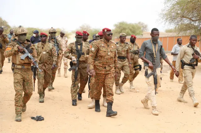 Burkina Faso President Lieutenant Colonel Paul-Henri Damiba is surrounded by soldiers, as he arrives to motivate his troops, after armed men killed civilians and militaries over the weekend in Seytenga, at airport in Dori, Burkina Faso June 15, 2022