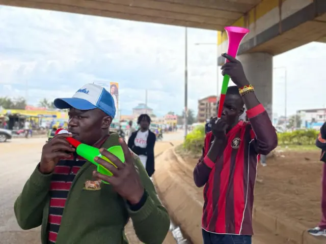 Supporters hold trumpets