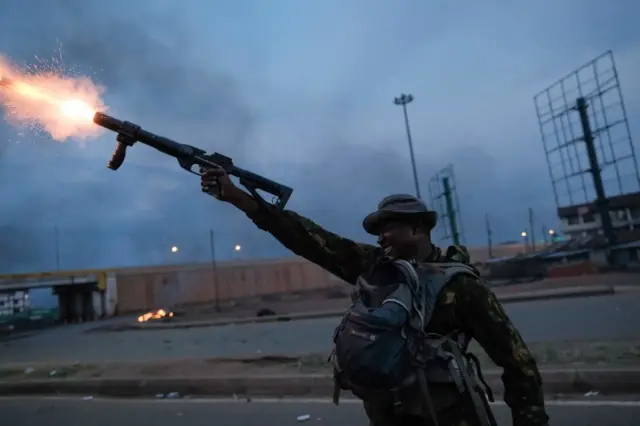 A Kenyan Police officer fires teargas towards supporters of Kenya's Azimio La Umoja Party (One Kenya Coalition Party) presidential candidate Raila Odinga, during a demonstration in Kisumu.