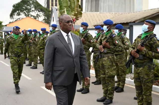 Ivory Coast's Minister of defence Tene Birahima Ouattara receives military honors as he arrives to meet with the relatives of the 49 Ivorian soldiers detained in Mali, in Abidjan on August 3, 2022.