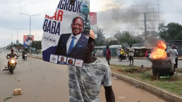 A demonstrator holds up a poster of Kenya"s opposition leader and presidential candidate Raila Odinga