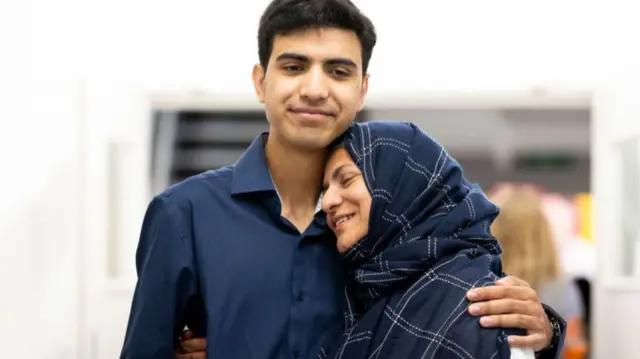 Sarim Rafique smiles with his mum after he receives his A-level results at Ffynone House School in Swansea.