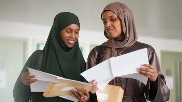 Nagma Abdi (left) and Zuhoor Haibe with their A-level results at Ark Putney Academy, south west London