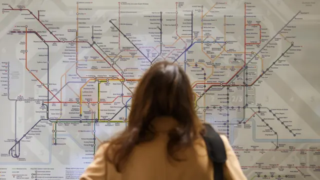 A woman looks at the tube map at the Waterloo underground station during a tube strike