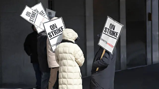 A group of workers on strike holding placards