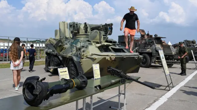 A man climbs over a tank Russia says it captured in Ukraine, during an exhibition in Rostov, Russia