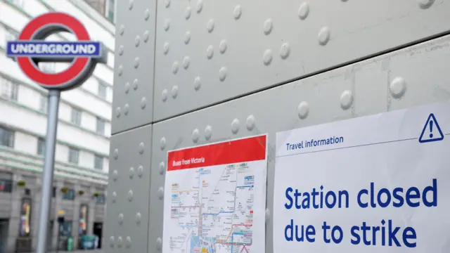 An informational poster is placed outside Victoria Underground Station during a strike in London,