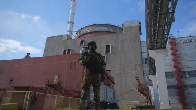 A Russian serviceman stands guard outside Zaporizhzhia nuclear power plant