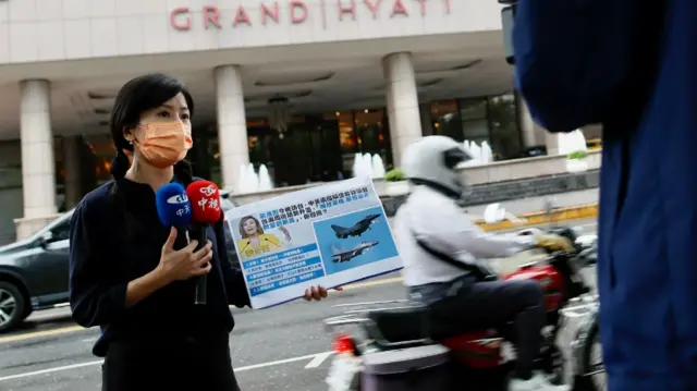 Local journalists film outside the Grand Hyatt hotel