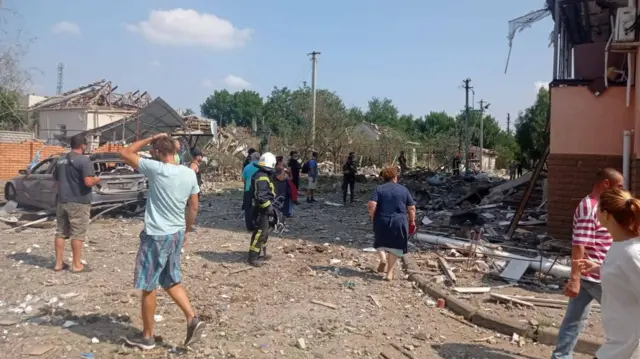 People outside a shell damaged residential building in Voznesensk, Ukraine