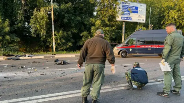 Russian officials investigate the scene after the car of Darya Dugina exploded outside Moscow