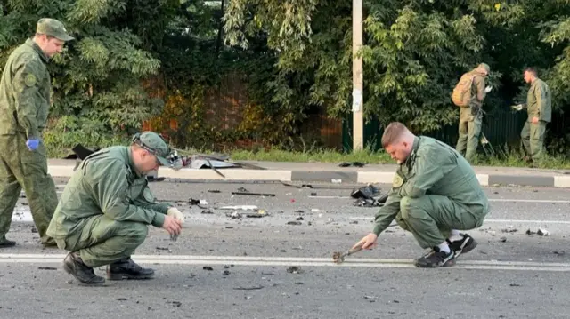 Investigators work at the site of a suspected car bomb attack that killed Darya Dugina in Moscow