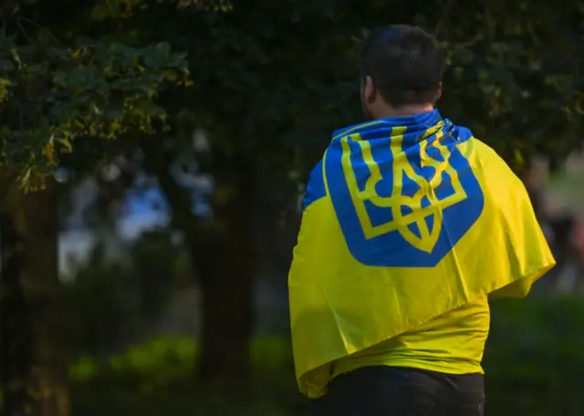 A protester wears a Ukrainian flag