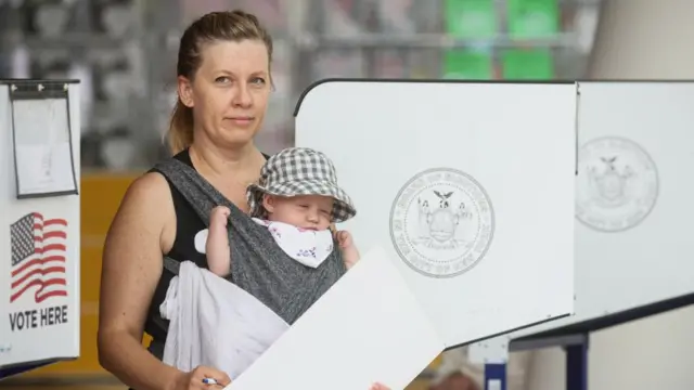 A voter poses with her baby at a polling station in New York City