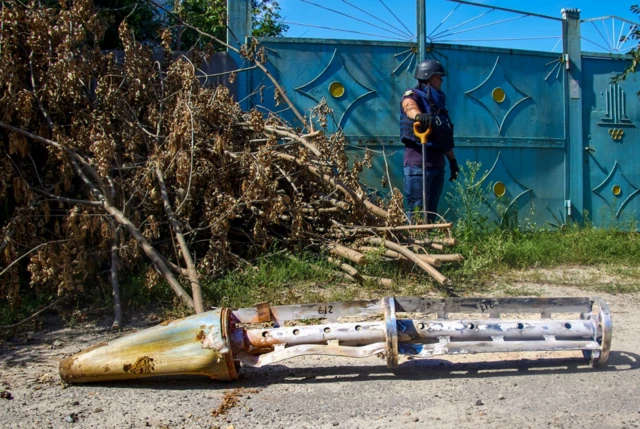 Policemen inspect debris of a rocket at the site of a shelling near Kharkiv, Ukraine, on 22 August