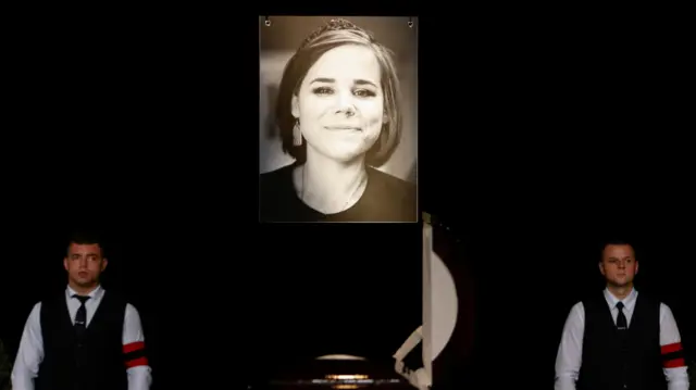 Participants stand next to a coffin during a memorial service for Darya Dugina