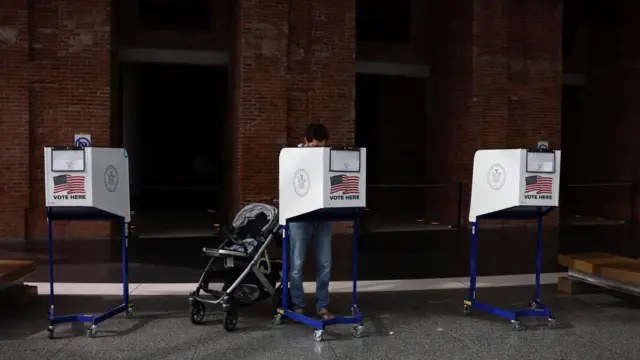 A voter with a pushchair stands at a polling station in New York City