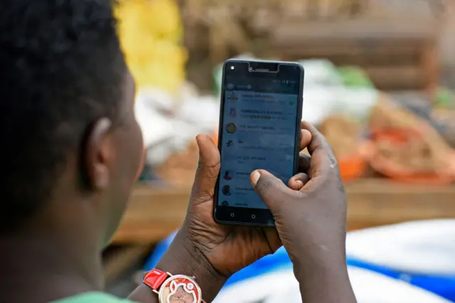 A woman uses a telephone in Kampala