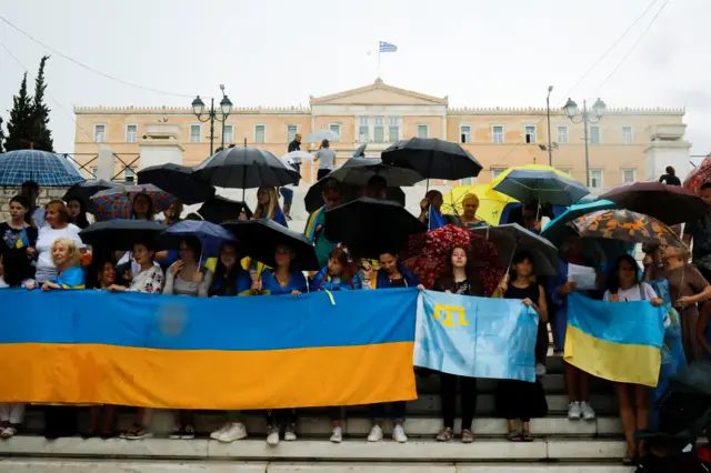 Ukrainians living in Greece hold a Ukrainian national flag as they gather to mark Ukraine's Independence Day in Athens, Greece