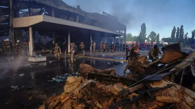 a smouldering shopping centre in Kremenchuk, following a Russian missile strike in June