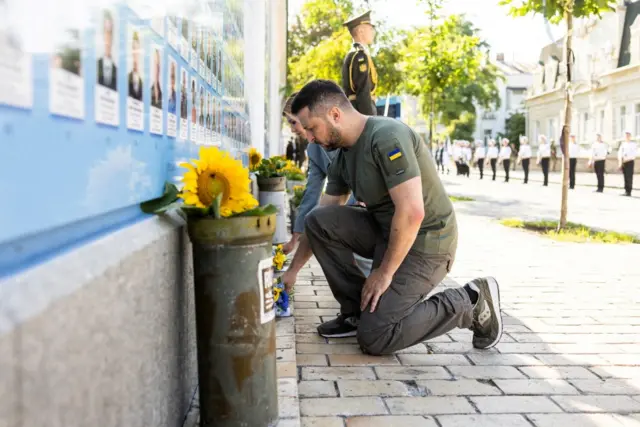 Zelensky and his wife place flowers at the Wall of Fallen Defenders