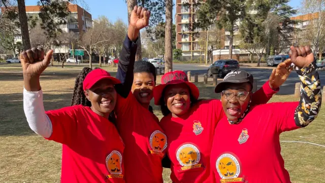 Women in red T-shirts raising their fists