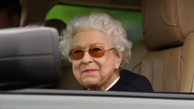 Queen Elizabeth II, in a car wearing sunglasses, at the Royal Windsor Horse Show in May