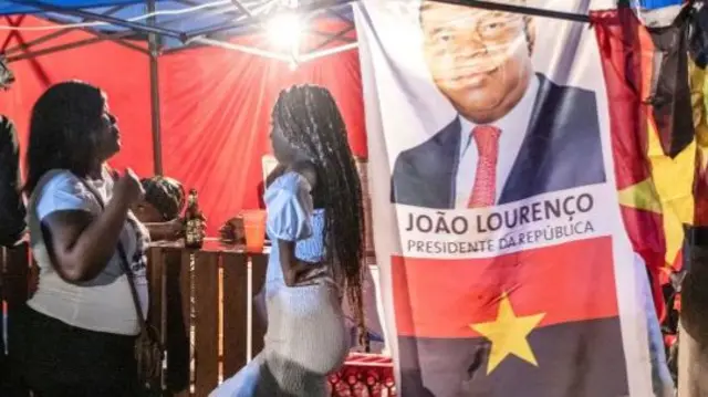 People buy and drink beer at a MPLA street party on Cape Island in Luanda on 21 August 2022