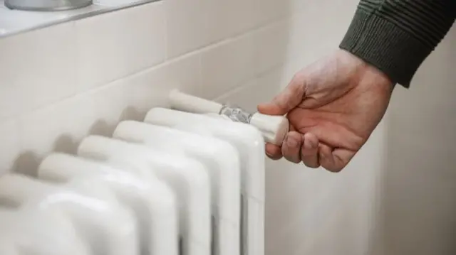 Hand turning off a radiator