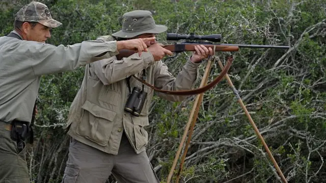 A professional hunter in South Africa points out a trophy to a client during a hunting safari in the Blaauwkrantz game reserve  - 2010