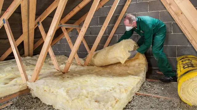 Man laying insulation in loft