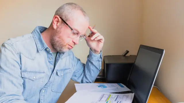 A stock photo of a man checking his energy bill