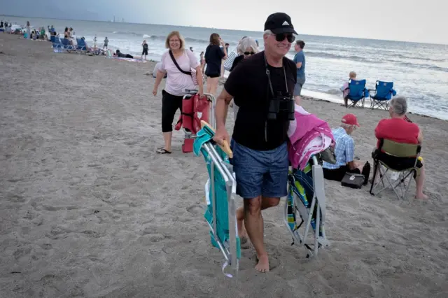 Beachgoers leave after the launch was cancelled