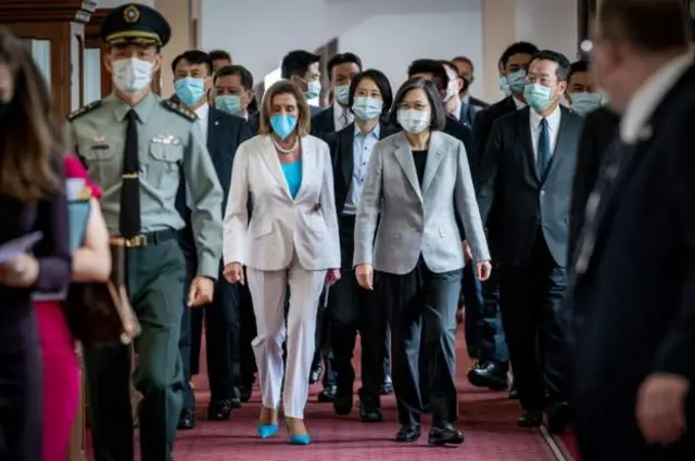 US House Speaker Nancy Pelosi and Taiwan's President Tsai Ing-wen walking together surrounded by a crowd