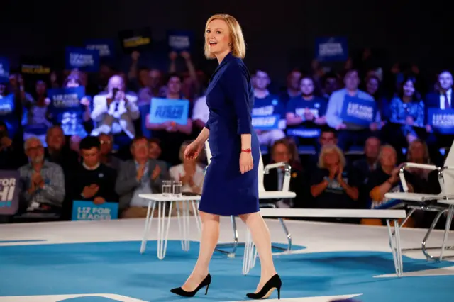 Liz Truss smiles as she walks on stage